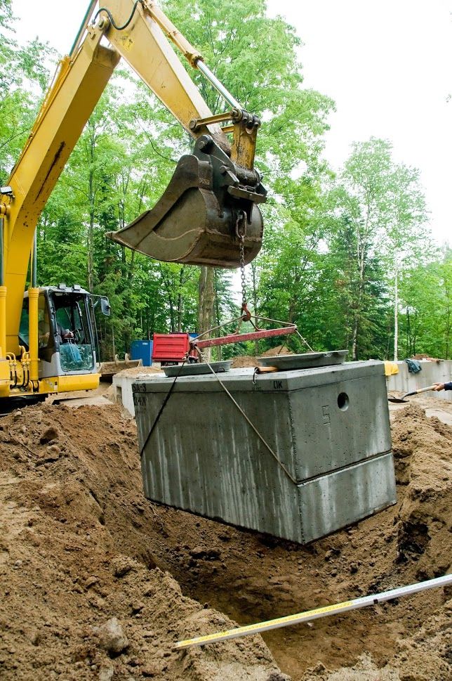 A yellow dump truck lifting a cement box
