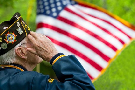 An armed service member saluting the United States flag in Okaloosa County, FL